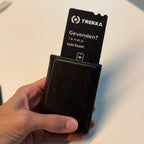 Trekka Portemonneepas steekt uit een zwarte leren portemonnee die in een hand wordt vastgehouden